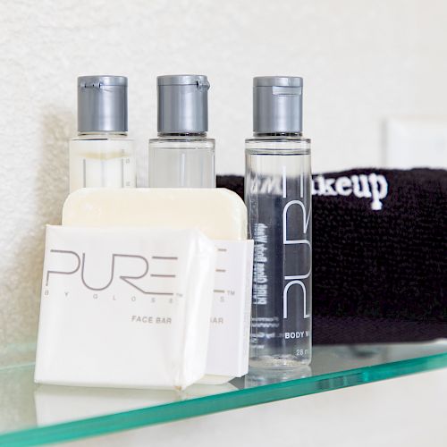 The image shows three bottles of toiletries, a bar of soap labeled 